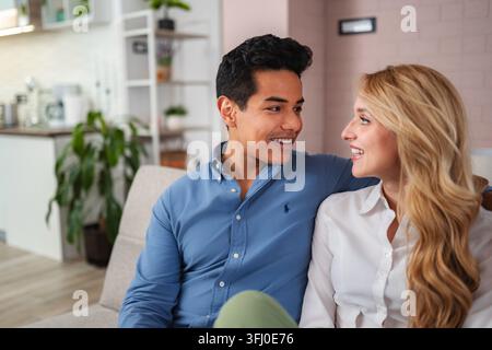 Happy young couple smiling and talking at home Stock Photo