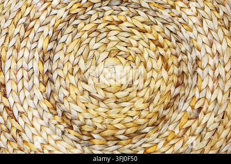Natural fiber weaving close up with circular braided design ideal for eco craft background ethnic country decor seamless wallpaper and macro abstract Stock Photo