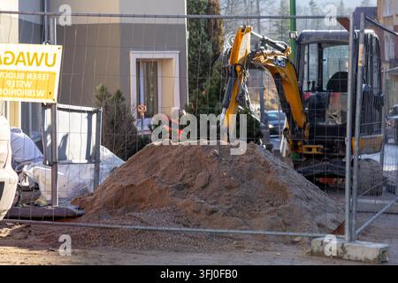 Szklarska Poreba, Poland - December 18, 2025: The construction machinery stands near a dirt heap on a building lot, representing infrastructure develo Stock Photo