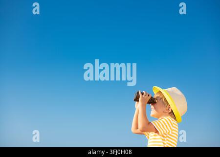 Child looking through binoculars in summer Stock Photo