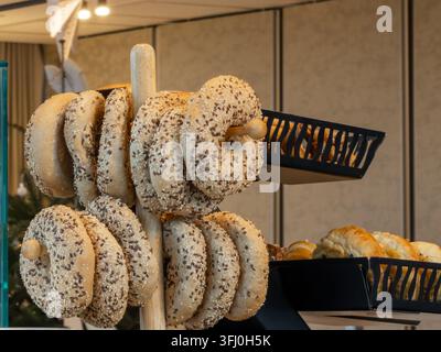 Tasty seeded bagels arranged neatly on a rack in a commercial food setting, representing a nutritious morning meal option in a high-end hospitality en Stock Photo