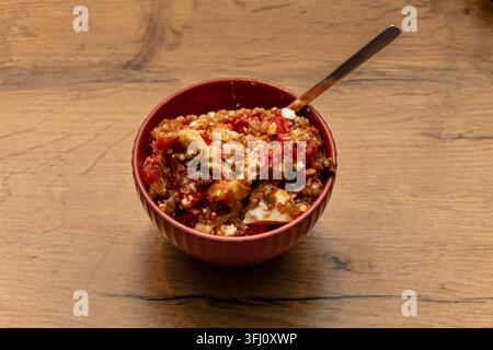 homemade bell pepper and eggplant salad with cheese served in a bowl, prepared as a healthy traditional vegetable side dish. Stock Photo