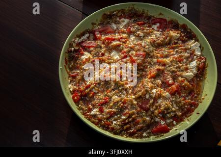 homemade bell pepper and eggplant salad served in a bowl with fresh vegetables and cheese, prepared as a traditional healthy side dish. Stock Photo