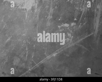 Close-up abstract background of a dark grey cement wall featuring distinctive white scratches, diagonal line marks, and grunge plaster textures Stock Photo