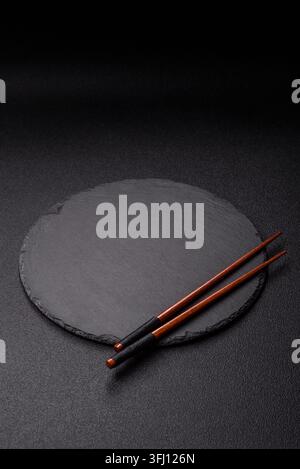 Empty slate board with wooden chopsticks for Asian food. Empty slate board as a food background for your design Stock Photo