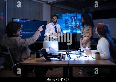 Technology professionals presenting digital analytics and software interface during corporate strategy meeting in modern innovation office environment Stock Photo