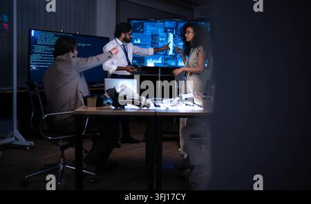 Technology professionals presenting digital analytics and software interface during corporate strategy meeting in modern innovation office environment Stock Photo