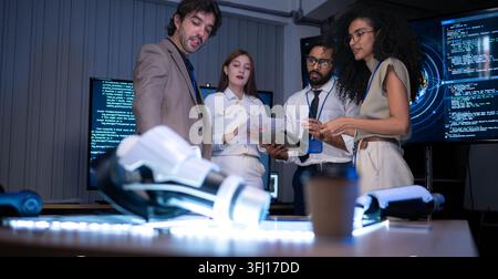 Business and technology professionals discussing software development and digital innovation project in high tech office with coding screens and robot Stock Photo
