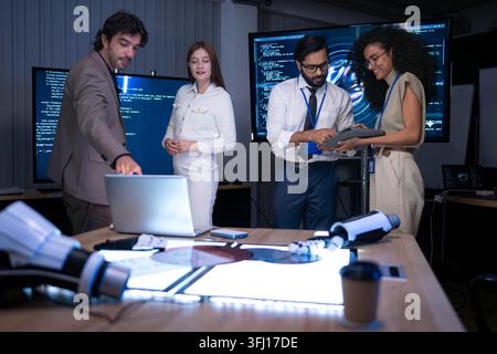 Business and technology professionals discussing software development and digital innovation project in high tech office with coding screens and robot Stock Photo