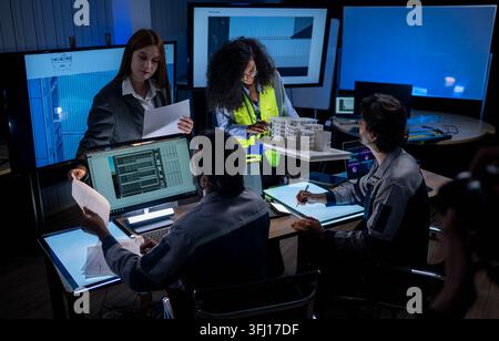 Multicultural engineering and design team collaborating on architectural development project with digital drafting tools and computer workstations Stock Photo