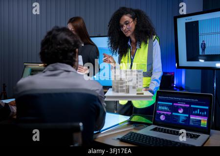 Multicultural engineering and design team collaborating on architectural development project with digital drafting tools and computer workstations Stock Photo