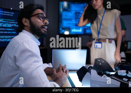Software engineer discussing advanced virtual reality technology and digital product development in futuristic innovation laboratory workspace Stock Photo