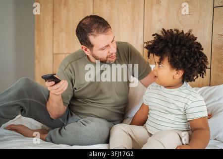 Father and son bonding on bed talking Stock Photo