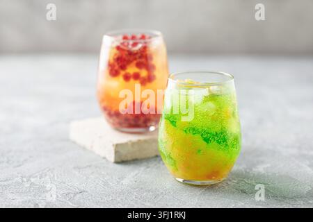 Glasses of homemade fruit lemonade with popping boba or bubble pearls. Trendy summer drink Stock Photo