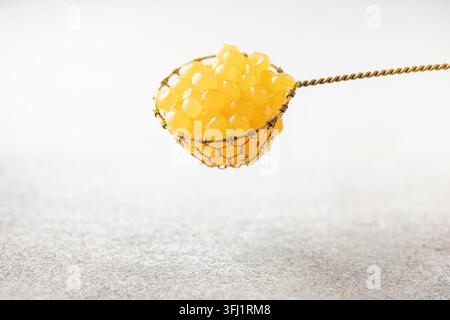 Orange juice balls or popping boba in strainer. Ingredient for trend drinks Stock Photo