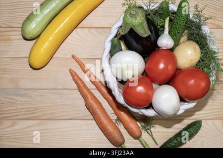 A colorful assortment of garden vegetables, including zucchini, tomatoes, cucumbers, carrots, onions, garlic, potato and eggplant. Stock Photo