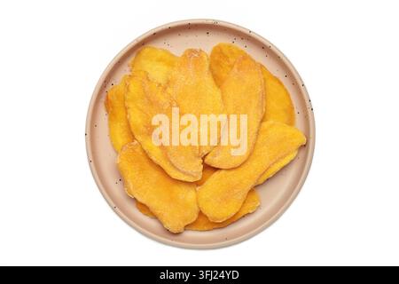 Slices of dried mango on beige plate isolated on white background. Top view Stock Photo
