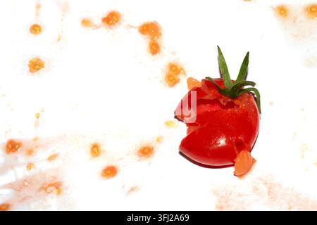A squashed splattered and crushed broken fresh tomato with seeds Stock Photo