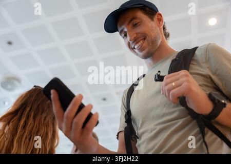 Happy man traveling using smartphone in airport Stock Photo