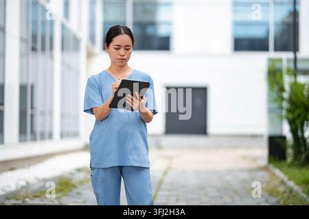 Asian medical professional using digital tablet outside clinic Stock Photo