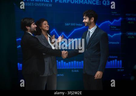 Business professionals shaking hands after a successful technology meeting, symbolizing partnership, teamwork, digital transformation, and corporate s Stock Photo