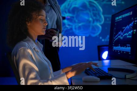 Data analyst monitoring financial charts and AI driven business intelligence on a computer, representing analytics, machine learning, and digital deci Stock Photo