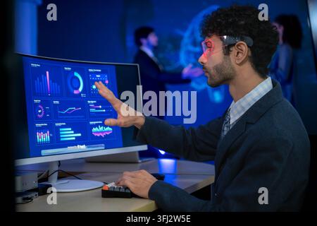 Business executive wearing smart glasses analyzing digital dashboards and business intelligence metrics in a modern office, demonstrating AI powered a Stock Photo