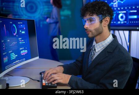 Business executive wearing smart glasses analyzing digital dashboards and business intelligence metrics in a modern office, demonstrating AI powered a Stock Photo