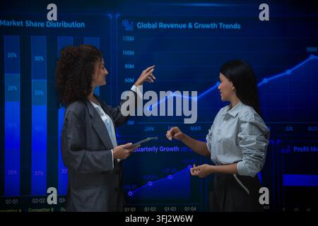 Business professionals analyzing performance metrics and annual growth trends using interactive financial dashboards during a strategy meeting Stock Photo