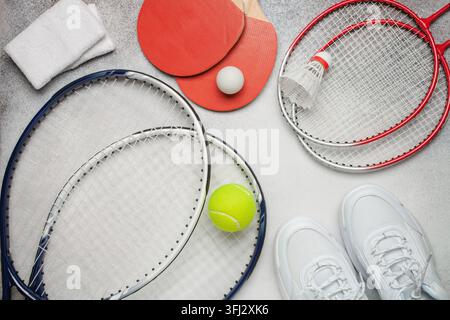 Tennis paddle rackets with ball on grey background. Summer sport activity concept. Top view Stock Photo