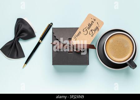 Happy Father's Day concept. Gift box, words and coffee on a blue background. Top View Stock Photo