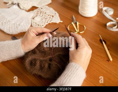 Woman's hands knitting wool yarn pattern. Close up picture. Stock Photo
