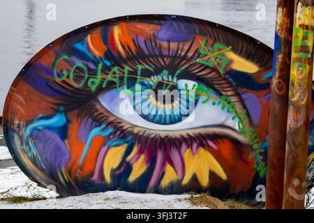 STAVANGER, NORWAY – FEBRUARY 7, 2026: Colorful street art depicting a large blue eye covers a curved industrial structure in the outdoor playground ar Stock Photo