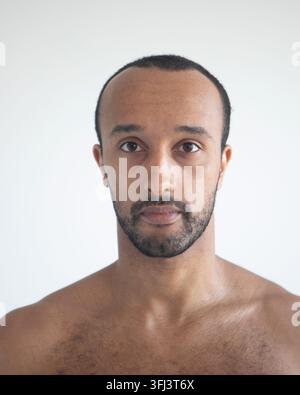 Dark-skinned man, head close-up over white background. Stock Photo