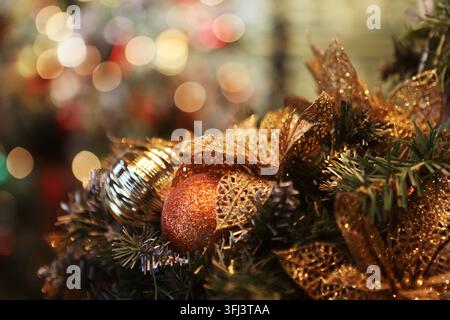 Closeup of Festively Decorated Outdoor Christmas tree with bright red balls on blurred sparkling fairy background. Stock Photo