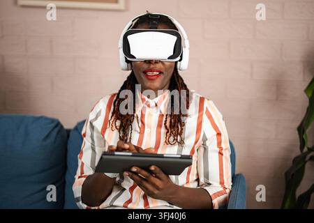Woman wearing VR headset and using digital tablet Stock Photo