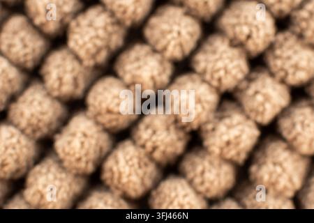 Beige knit fabric creating an abstract soft blurry pattern texture Stock Photo