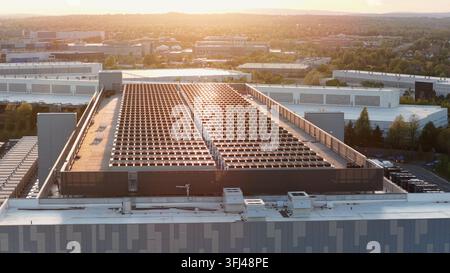 Aerial sunset rise flyover of modern data center in Ashburn, Virginia showing large scale server infrastructure and cooling systems representing AI cl Stock Photo