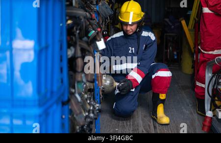 Firefighters prepare protective equipment and breathing apparatus inside a rescue equipment storage area before training Stock Photo