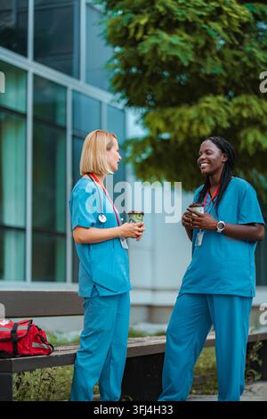 Healthcare workers having coffee break outside hospital building Stock Photo