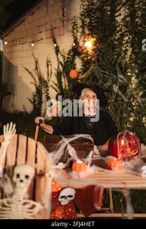 Senior woman dressed as a witch celebrating Halloween Stock Photo