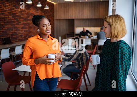 Diverse businesswomen discussing during coffee break in office Stock Photo