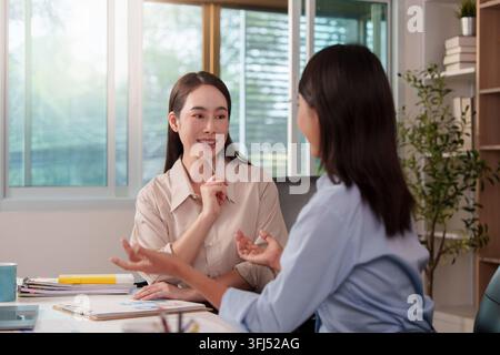 Asian businesswomen discussing financial strategy during office meeting for corporate growth Stock Photo