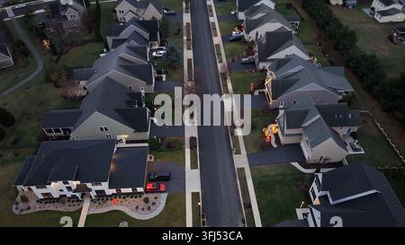 New modern Single family houses with christmas decoration in suburb of american town. Aerial tilt up wide shot. Dusk scene with traffic on street. Dus Stock Photo