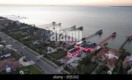 Red Lighting Villa in Apollo beach with private jetty during sunset. Illuminated mansion in Florida. Aerial top down approaching shot. Stock Photo