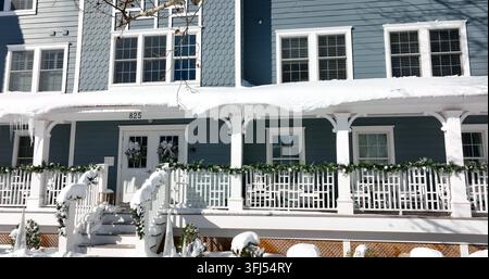 Blue apartment building in winter snow. Icicles hang from snowy roof. Winter snow with Christmas decroration, Cape May, New Jersey. Stock Photo