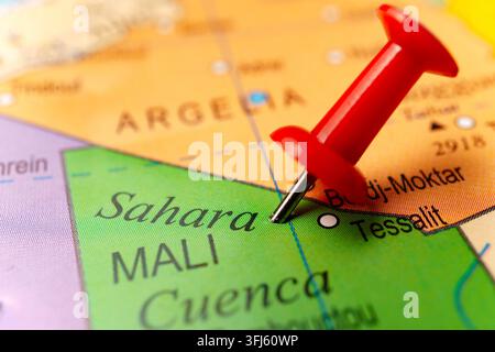 Red push pin pointing to sahara on a world map, indicating travel, destination, or a specific location Stock Photo