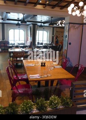 SITKA, ALASKA - JUN 27, 2024 - Modern restaurant dining area featuring elegantly prepared tables, setting stage for sophisticated culinary encounter w Stock Photo