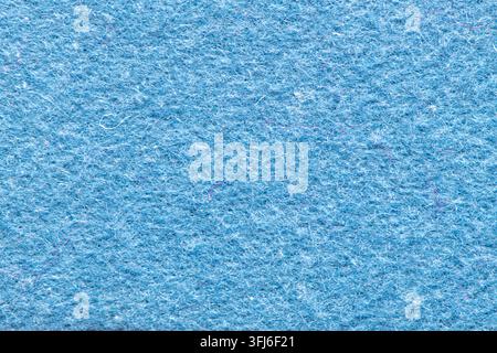Close-up macro shot of a soft blue felt fabric surface featuring a dense, matte, non-woven matted fiber texture with light and dark blue tones. Stock Photo