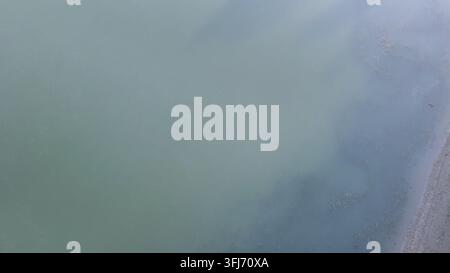 Po River water showing swirling patterns and color variations, reflecting the aftermath of a hailstorm and creating an organic, abstract texture from Stock Photo